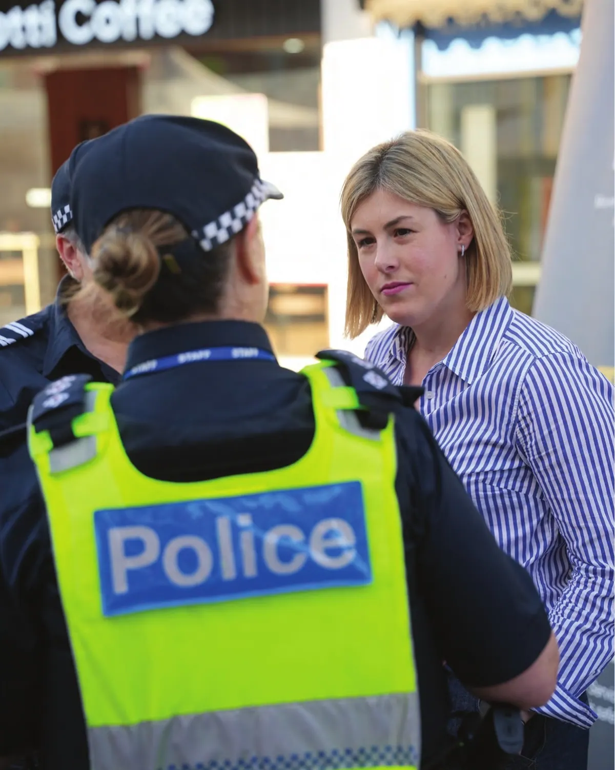 Jess Wilson talks with a Victoria Police officer outside a café