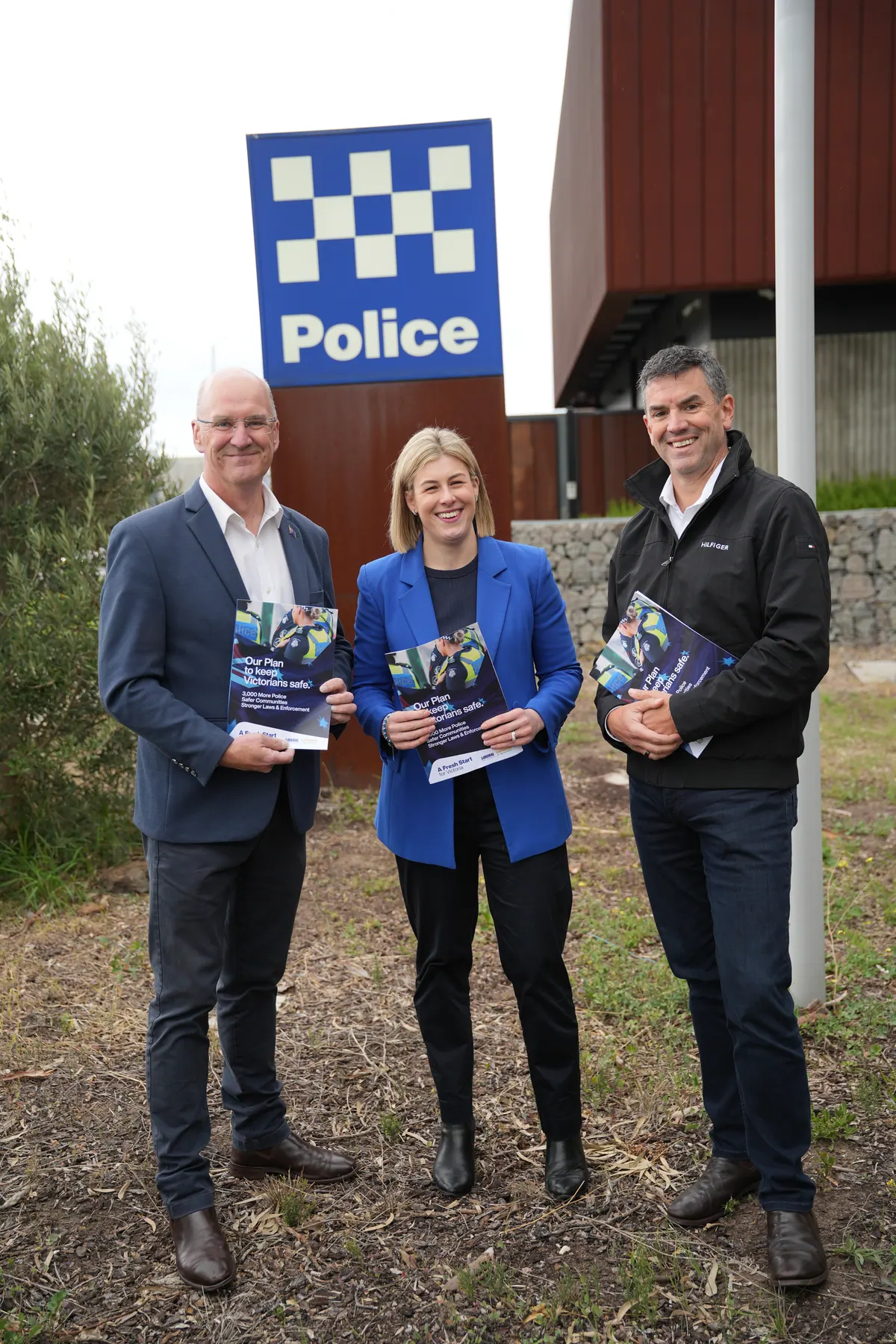 Jess Wilson outside a police station holding copies of the plan to keep Victorians safe