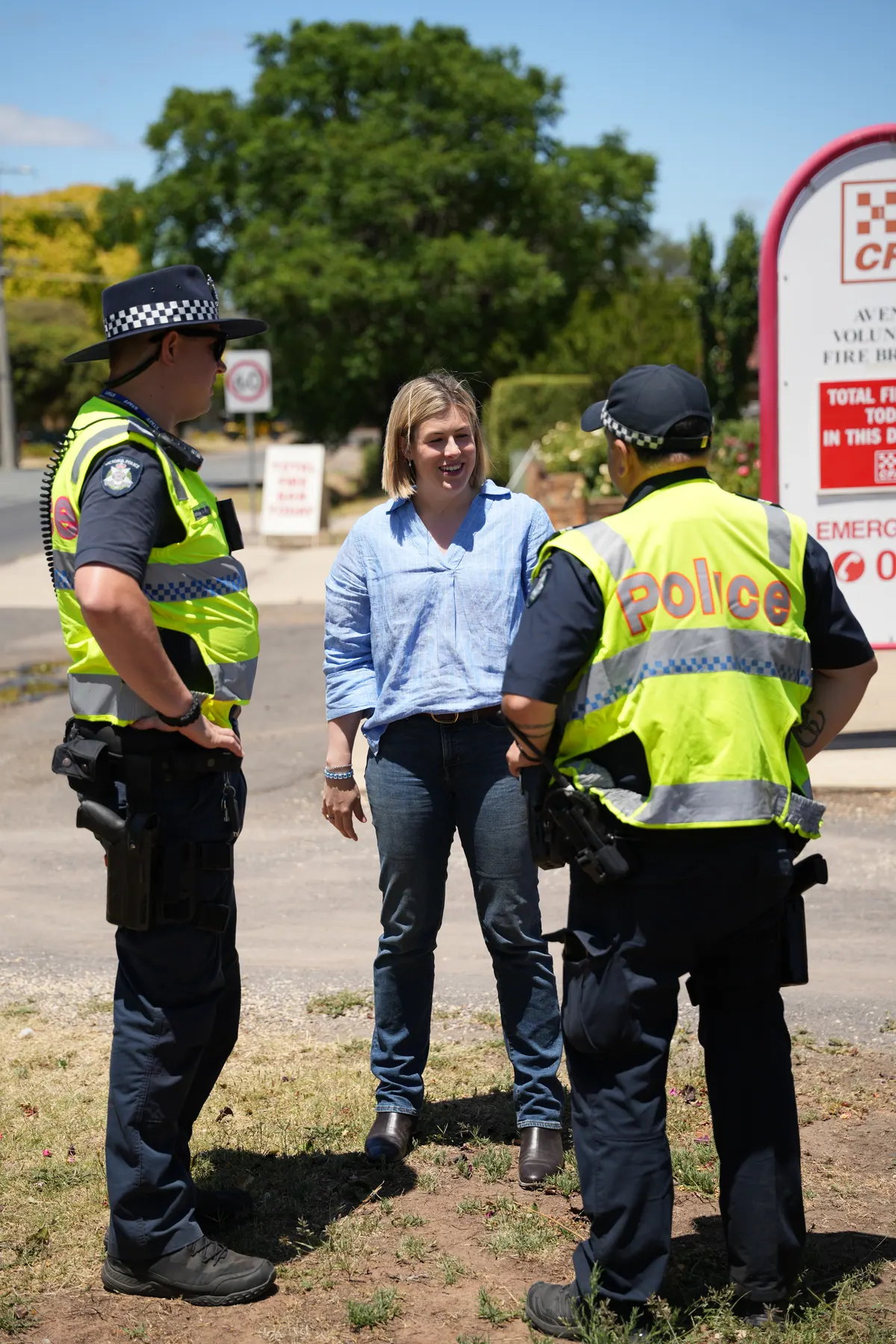 Jess Wilson speaks with two Victoria Police officers on a country street