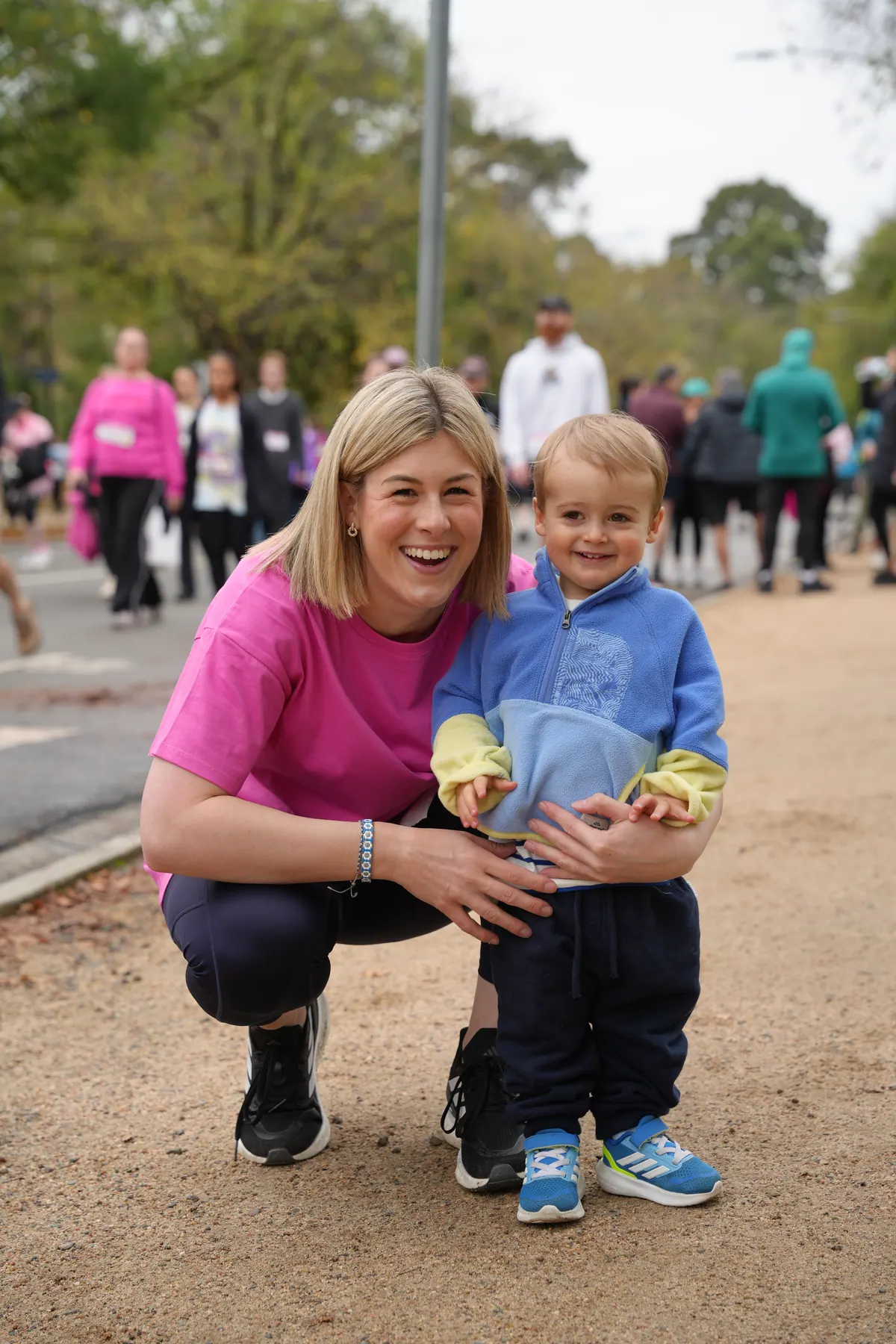 Jess Wilson crouches beside her young son at a community fun run